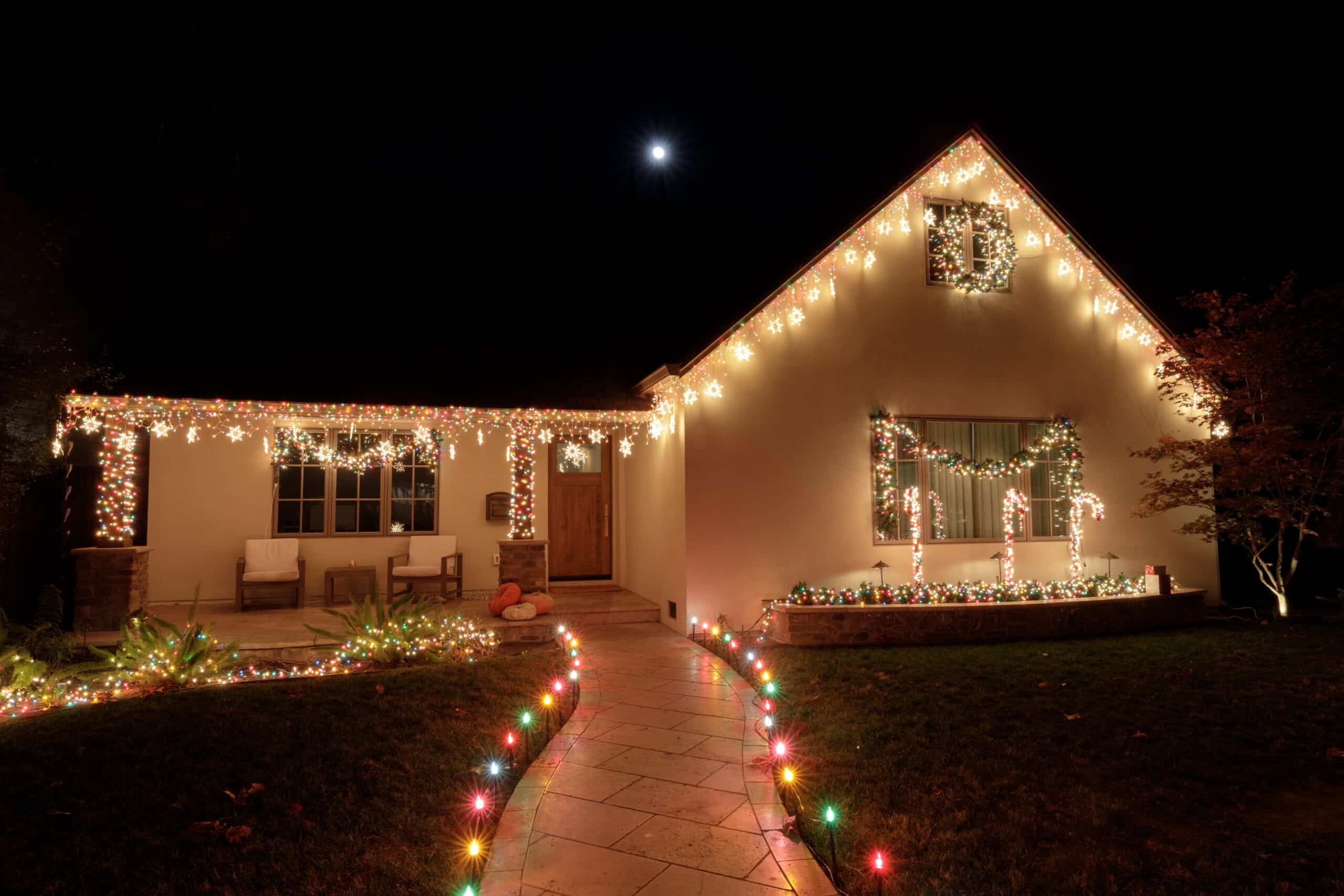 House decorated with colorful Christmas lights at night.