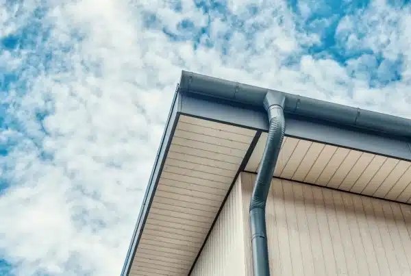 House roof and gutter against cloudy sky