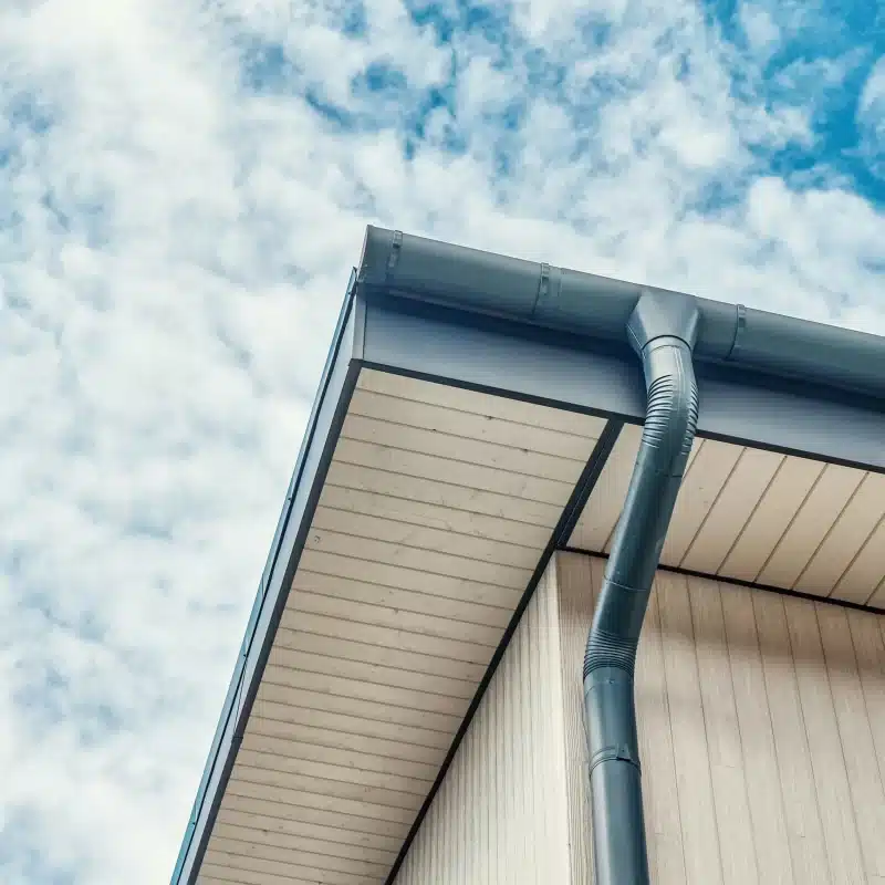 House roof and gutter against cloudy sky