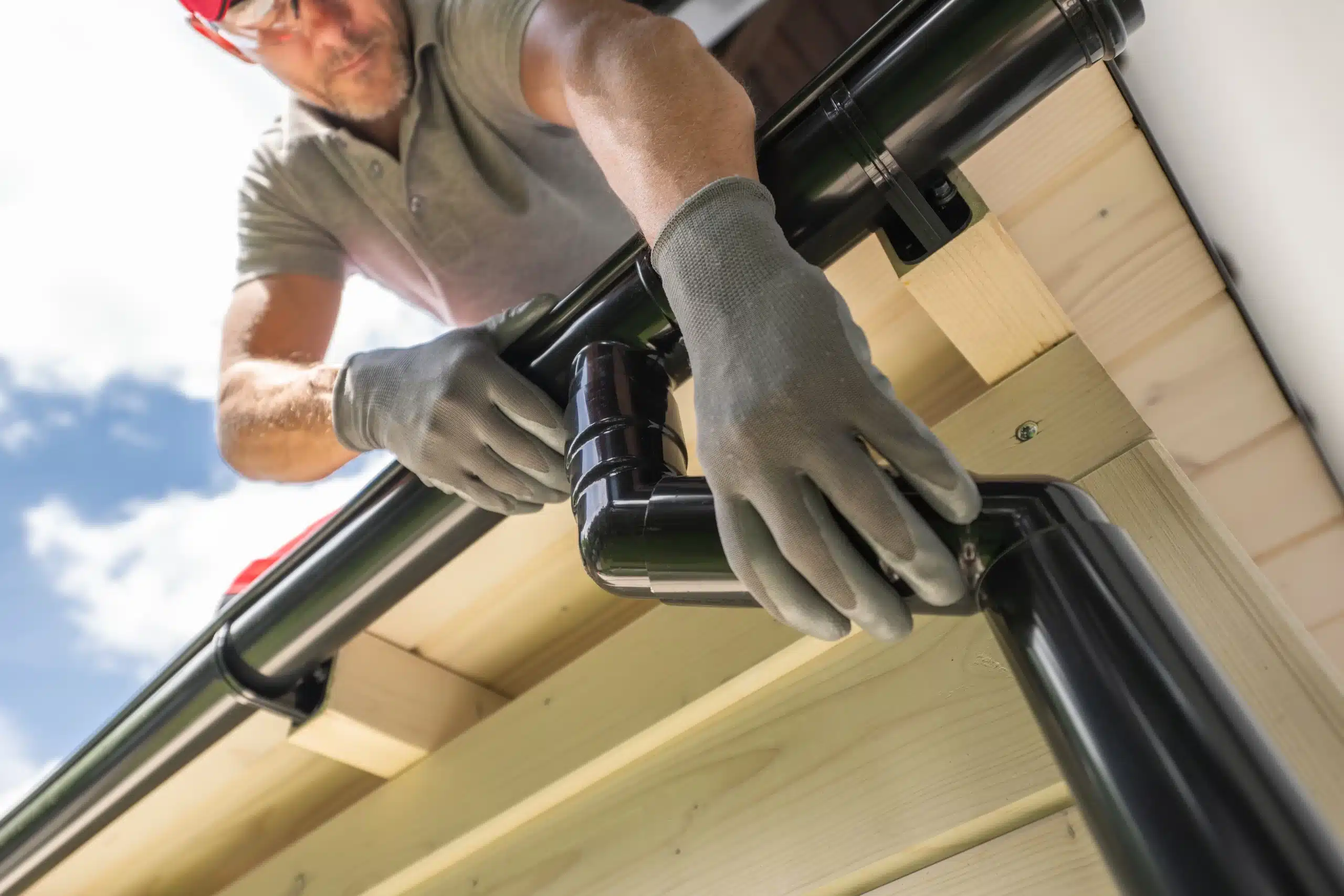 Worker installing house gutter system