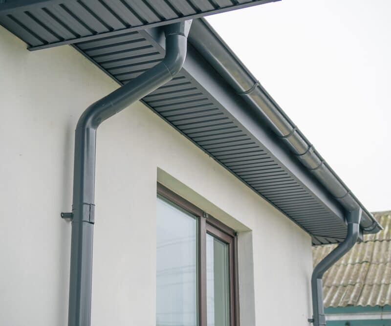 Gray rain gutter system on house exterior
