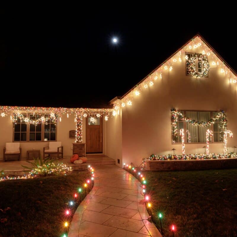 House decorated with colorful Christmas lights at night.