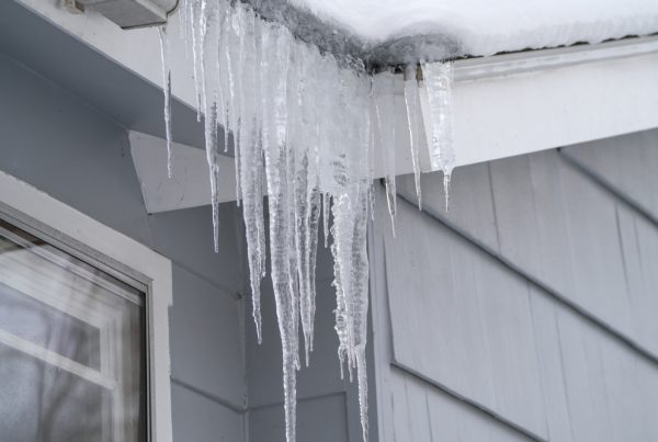 Icicles hanging from house roof in winter.